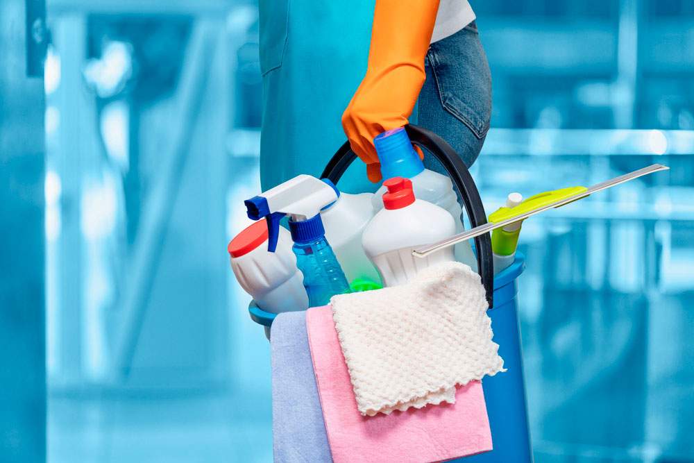 Empleado de empresa de limpieza a domicilio en Murcia sosteniendo productos de limpieza
